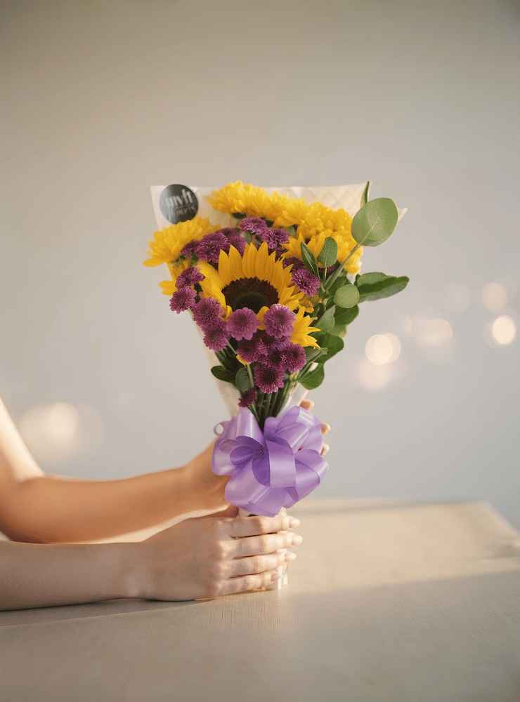 Ramillete de margaritas con girasol_11zon Ramillete con girasol, margaritas amarillas, flores moradas y eucalipto, ideal para regalar alegría, frescura y cariño sincero.