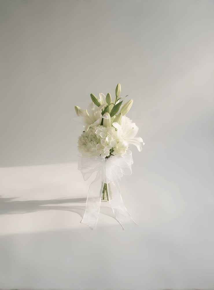 Arreglo carro Boda_11zon Arreglo floral para carro de boda con lirios blancos, hortensias blancas y lazo delicado, ideal para celebrar amor, elegancia y unión.